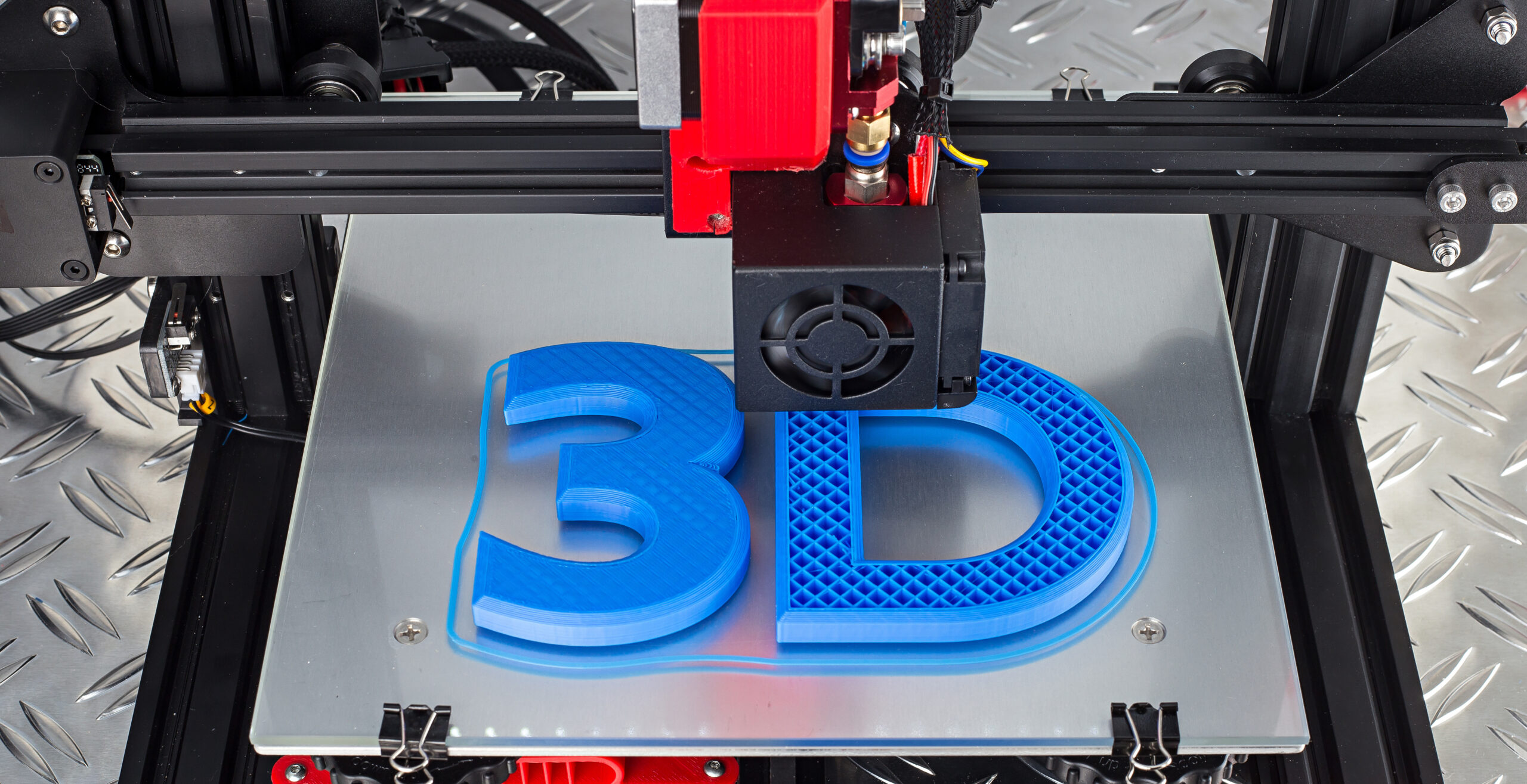 Red black 3D printer printing blue logo symbol on metal diamond plate future technology modern concept